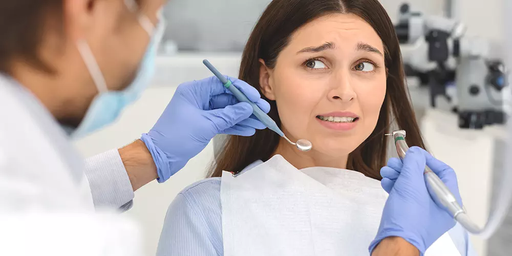 ängstliche Frau beim Zahnarzt im Behandlungsstuhl